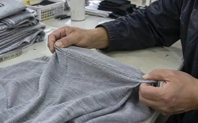 Hands checking the extension of a jersey seam