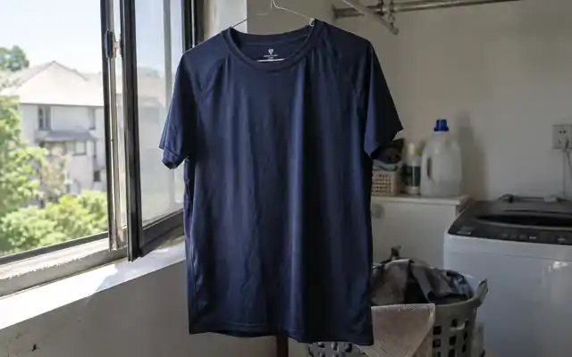 Navy training shirt air drying beside a laundry-room window