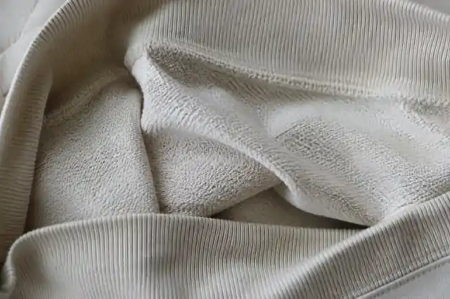 Close-up of cream loopback sweatshirt fabric and rib construction