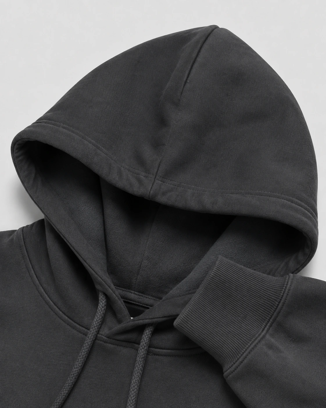 Close view of a charcoal heavyweight hoodie hood, rib cuff and drawcord